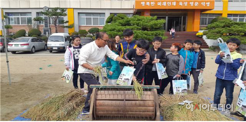 학생들이 키운 벼를 탈곡하는 모습