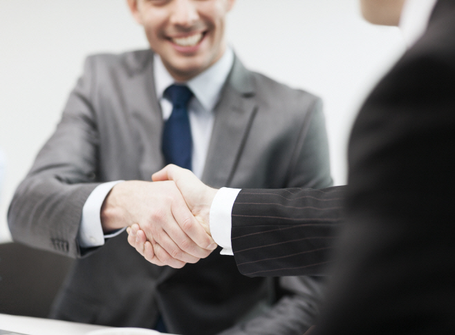 two businessmen shaking hands in office