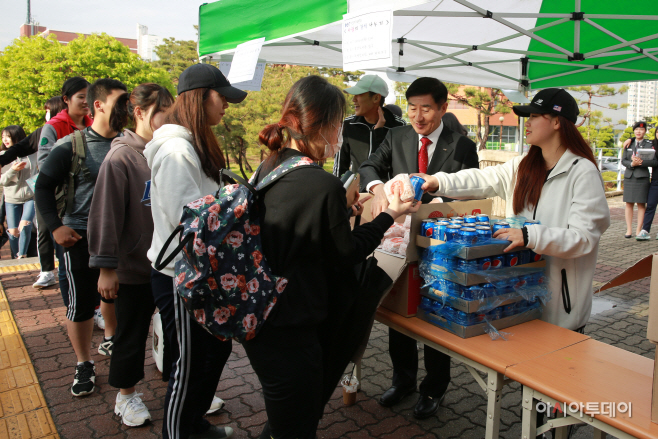 총장이 학생들에 험버거를 나눠주고 있다.