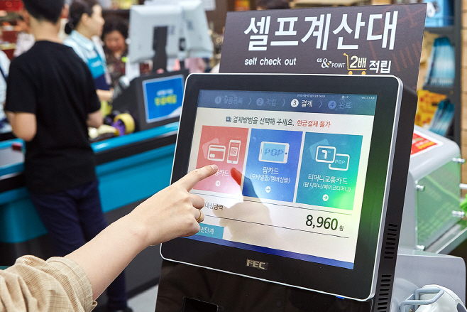 고객이 GS수퍼마켓 셀프계산대에서 계산을 하고 있다