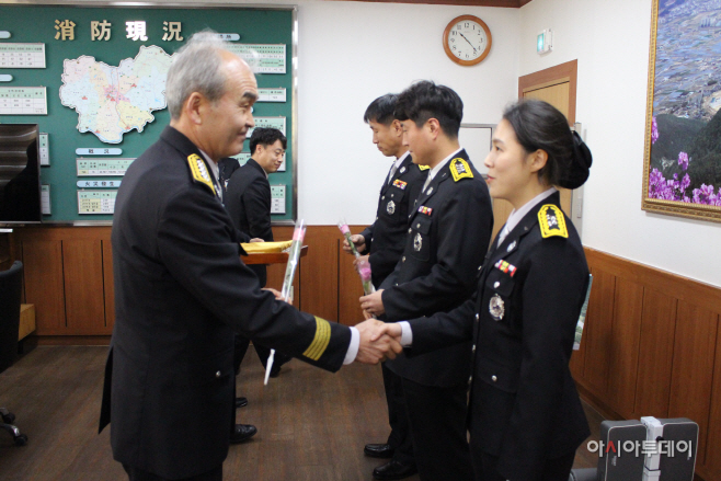 소방사 김윤덕에게 축하인사를 하는 사진