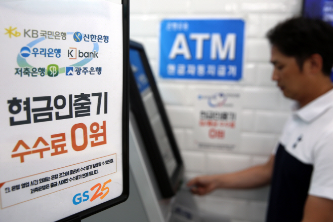 GS25에서 고객이 ATM을 사용해 현금을 인출하고 있다