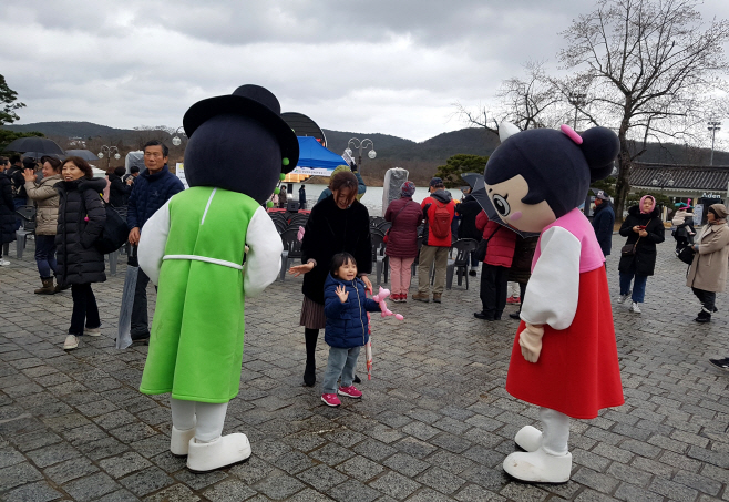호반광장에서 어린이가 선비투어 캐릭터와 즐기고 있다