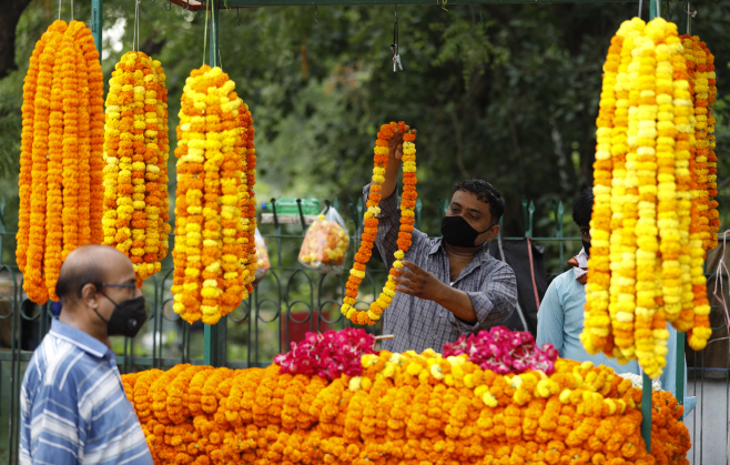 코로나19 이후 재개방된 사원에서 꽃 파는 인도 상인