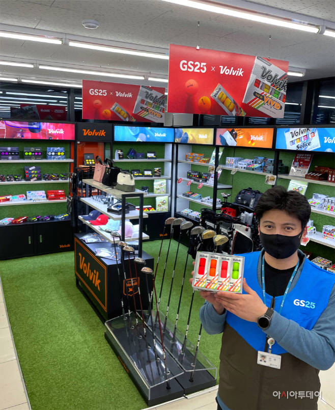 (첨부3) GS25 직원이 골프용품 매대앞에서 상품을 들고 있다