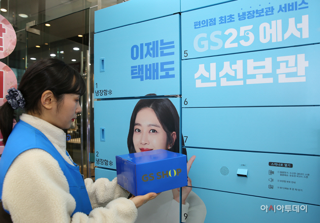 GS25 BOX25에 모델이 GS샵 박스를 넣고 있다.