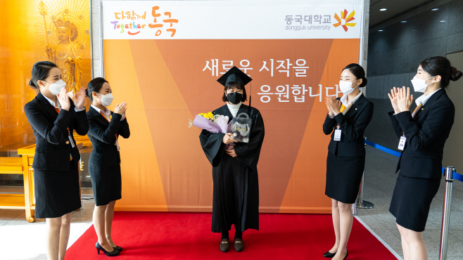 포토월을 배경으로 사진을 찍고 있는 졸업생