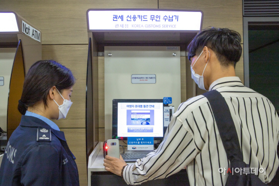 자진신고한 여행객이 무인수납기에서 세금을 납부 하고 있다