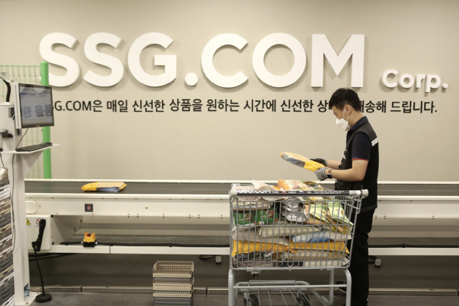 [사진자료1] 작업자가 자동화 소터에 상품을 투입하는 모습 (1)