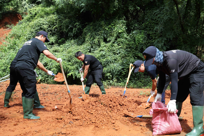 흘러내린 토사를 삽으로 정리하고 있다