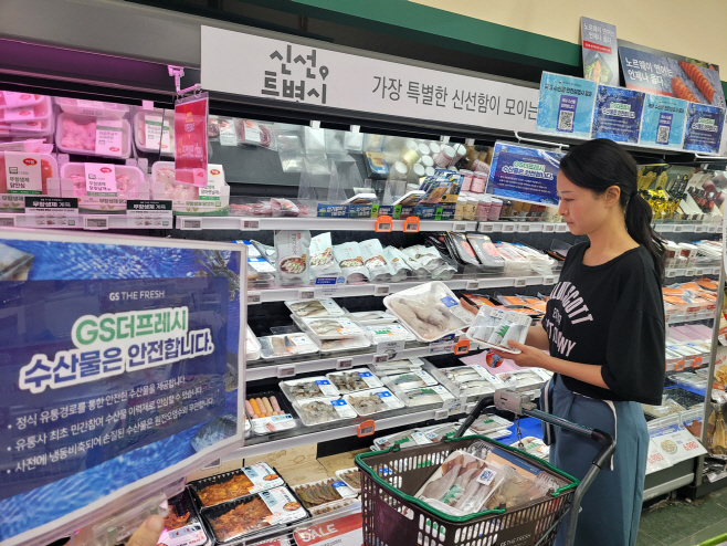 GS더프레시에서 소비자가 수산물을 고르고 있다_1