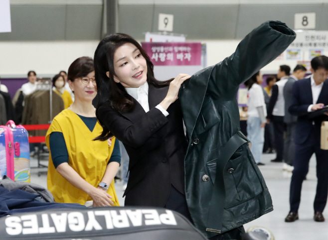 적십자 바자회서 재활용 의류 입어보는 김건희 여사