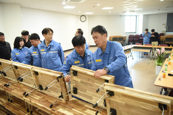 2) 목공예재능봉사단이 손수 제작한 원목밥상을 확인하고 있다.