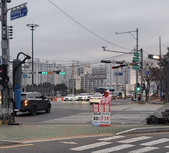 비오는날 우의를 입고 작시사거리에서 퇴근인사를 하고 있다