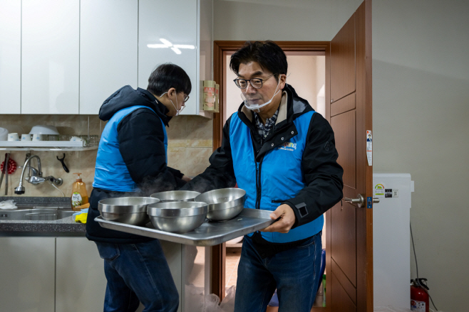 [쿠팡 이미지2] 정종철 쿠팡풀필먼트서비스 대표이사(오른쪽)와 직원들이 용인 완장3리 마을회관에서 어르신들에게 드릴 떡국을 나르고 있다