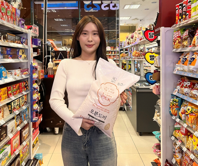 [사진자료1] GS25에서 모델이 오분도미 상품을 들고 포즈를 취하고 있다 (1)