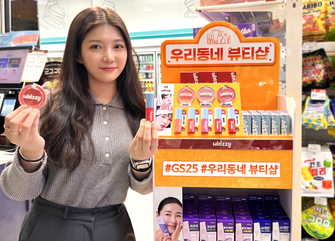[이미지1] 모델이 GS25 뷰티 특화 매대 앞에서 위찌 상품을 들고 포즈를 취하고 있다.