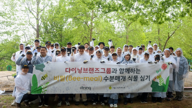 [붙임1] 다이닝브랜즈그룹 임직원들이 '수분 매개 식물 심기' 캠페인 단체사진을 촬영하고 있다.