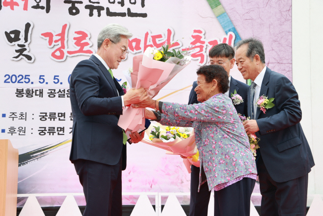 #1. 250529 보도사진3(유족 배병순 할머니가 오태완 군수에게 감사패와 꽃다발을 전달하며 환하게 웃고 있다)
