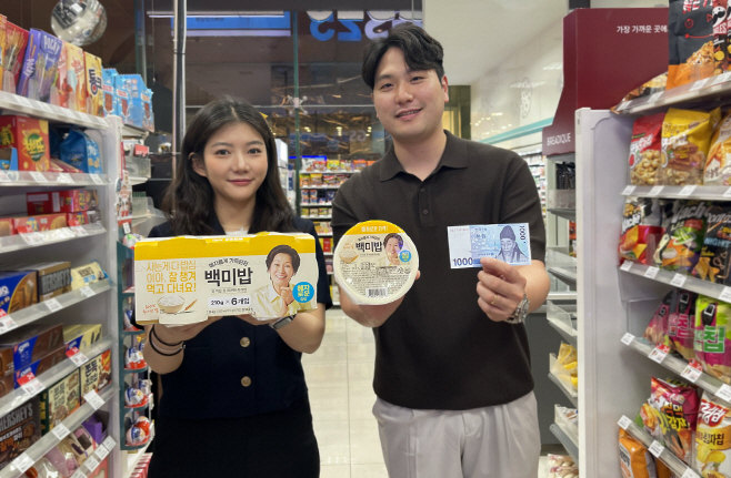 모델이 GS25가 업계 최저가 즉석밥으로 선보인 1000원 '혜자백미밥'을 들고 포즈를 취하고 있다.