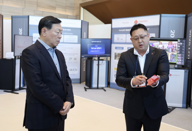 신동빈 롯데 회장(왼쪽)이 1월 9일 서울 잠실 롯데월드타워에서 진행한 '2025 상반기 VCM'에 앞서 열린 'AI 과제 쇼케이스'에서 롯데케미칼의 'AI 기반 컬러 예측 시스템'에 대한 설명을 듣고 있다.