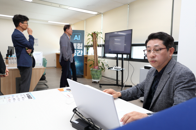 1. 한국석유공사 김동섭 사장(가운데)이 이달 2일 울산 본사에 마련한 AI 체험공간에 방문한 가운데 이승환 혁신팀장(오른쪽)이 AI를 직접 사용하는 모습