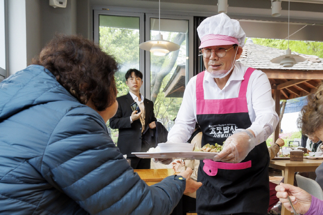 박강수 마포구청장이 효도밥상 어르신께 식사를 건네고 있다.