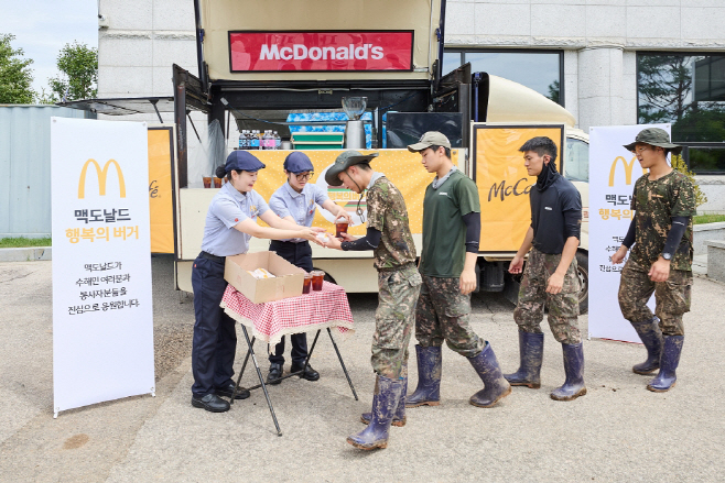 [보도사진1] 가평 지역 수해 복구에 참여한 군 장병들이 맥카페 음료트럭 앞에서 버거와 음료를 수령하고 있다