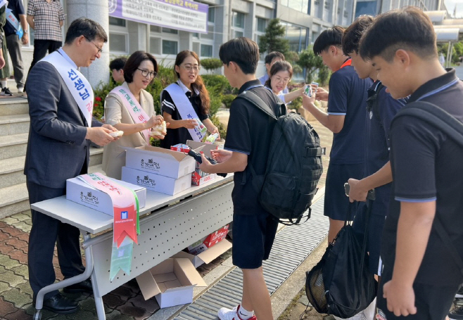 사진2_간식을 나눠주며 학생들을 맞이하는 교육장 및 밀성중학교 교직원들의 모습