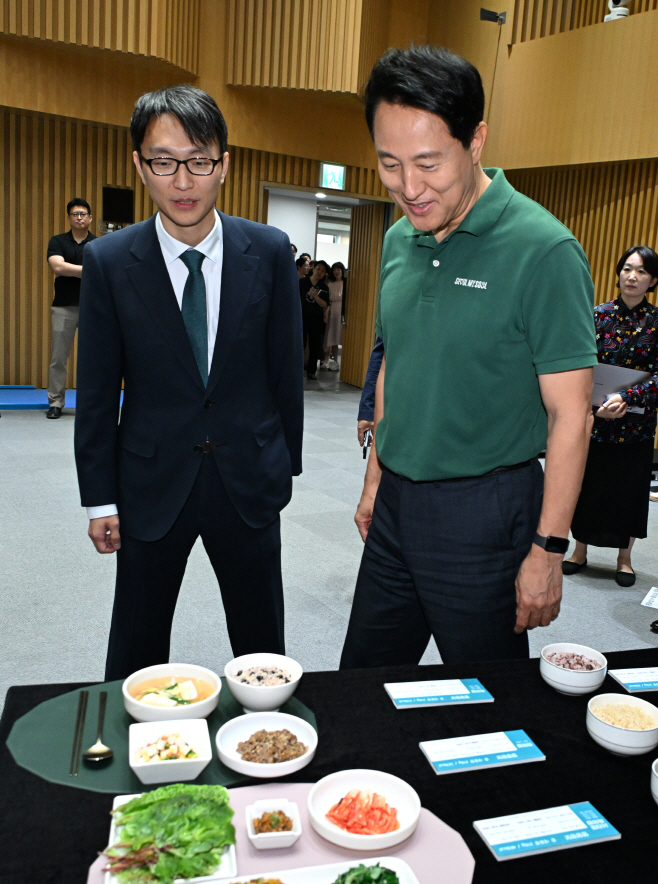 (사진1) 오세훈 서울시장이 10일(수) '9988 평생건강 서울' 기자설명회에서 정희원 건강총괄관과 저속노화 밥상을 살펴보고 있다.