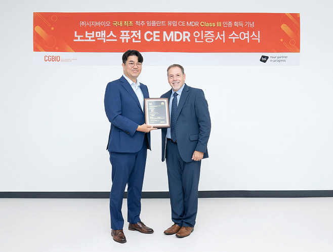 [사진자료1] 시지바이오 유현승 대표(왼쪽)와 빌 이노스(Bill Enos) BSI 글로벌 심사 총괄 디렉터가 ‘노보맥스 퓨전’ 유럽 CE MDR 인증서를 기념하며 촬영하고 있다.