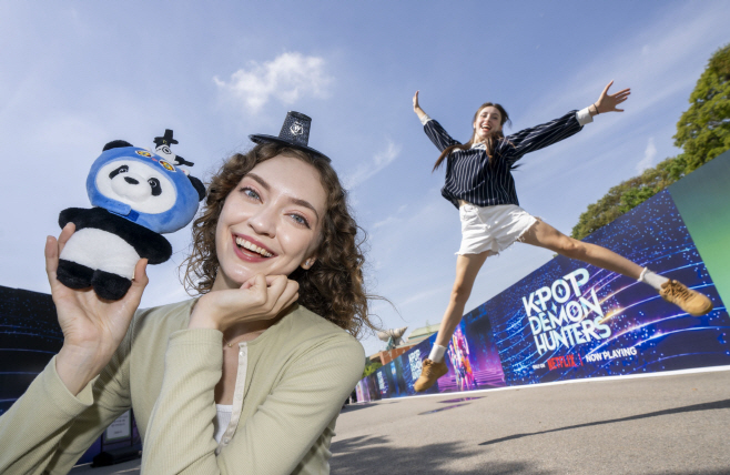 6. 판다 더피 인형을 들고 기념사진을 찍고 있는 관광객