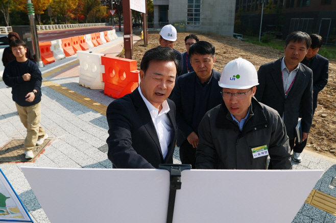 1.(사진)의왕 초평지구 송부로 연결도로 임시 개통(3)_(해설)김성제 시장이 송부로 연결도로 임시 개통 현장을 찾아 한국토지주택공사관계자로 부터 브리핑을 청취하고 도로 현장을 점검하고있다.