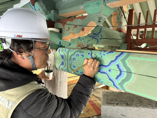 춘천 청평사 회전문 전통 단청에 동록 안료를 적용하는 모습(연화머리초 시문)