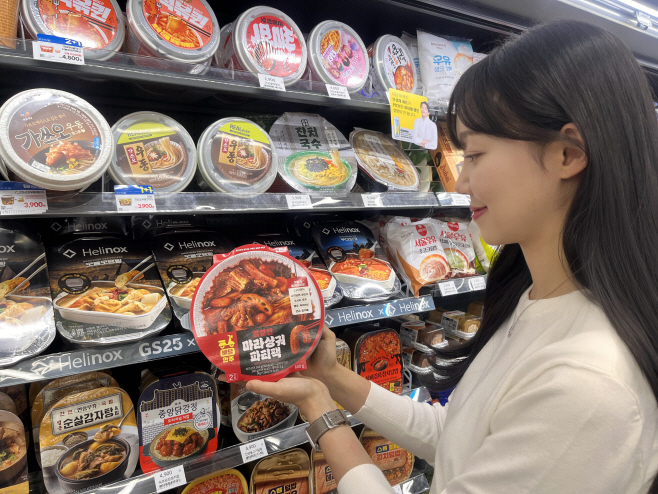 [사진자료2] GS25에서 모델이 마라샹궈파티팩을 바라보고 있다.