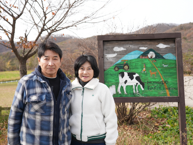 직접 그린 그림 앞에서 기념사진 촬영하고 있는 농장 대표 부부