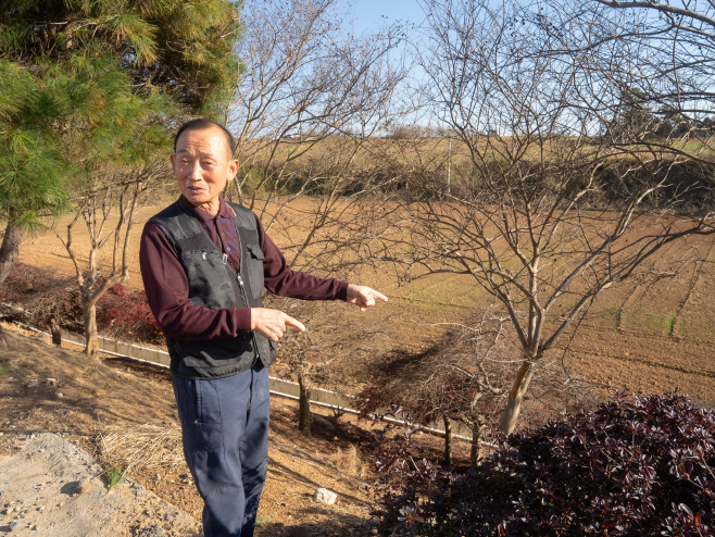 농장 부지경계에도 나무를 계속 심어 더 이상 심을 때가 없을 정도로 빽빽하게 나무와 꽃을 심고 있음을 설명하는 농장 대표