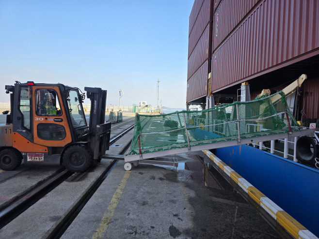 (사진1) 선광신컨테이너터미널에서 힌지식 포크슬롯을 활용해 개발한 승하선 이동용 사다리를 설치하고 있다