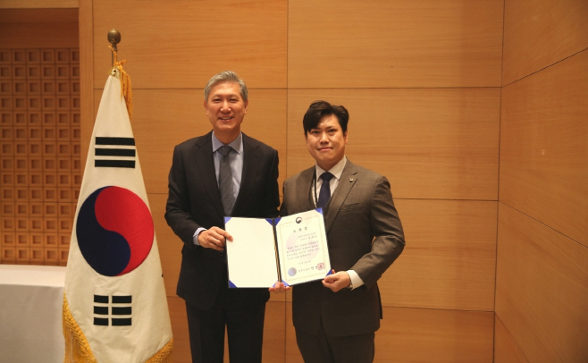 [하나투어 사진자료]지난 12일, 주중국 대한민국 대사관에서 북경지역 비자신청센터 정회윤 총괄 매니저(오른쪽)가 노재헌 주중국대사로부터 법무부 장관 표창을 전수받고 기념촬영을 했다.