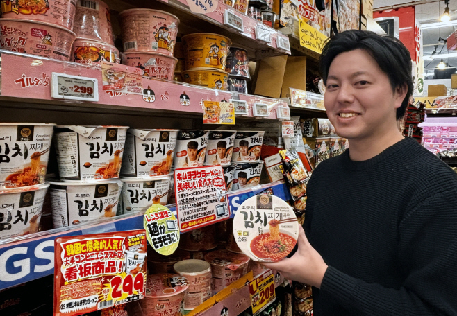 [첨부2]GS25가 PB라면 '오모리' 시리즈를 일본 돈키호테로 수출했다. 모델이 일본 돈키호테 매장에서 '오모리' 시리즈를 들고 포즈를 취하고 있다