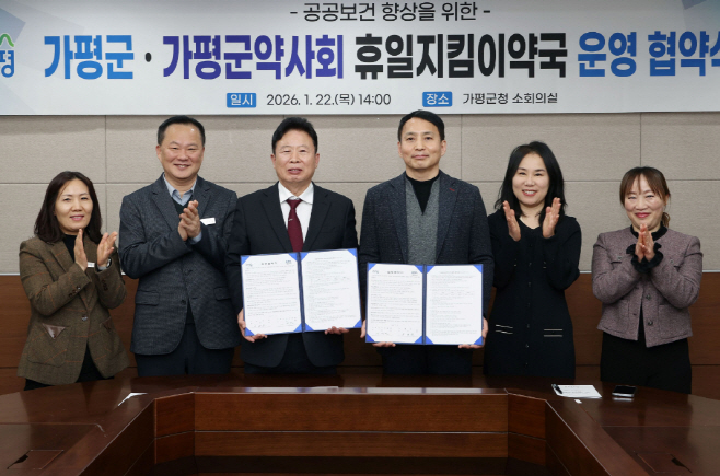 서태원 가평군수(사진 왼쪽에서 세번째)와 안병현 가평군약사회 회장(〃 네번째) 등이 22일 휴일지킴이약국 운영 협약식 후 협약서를 보이며 기념촬영을 하고 있다.