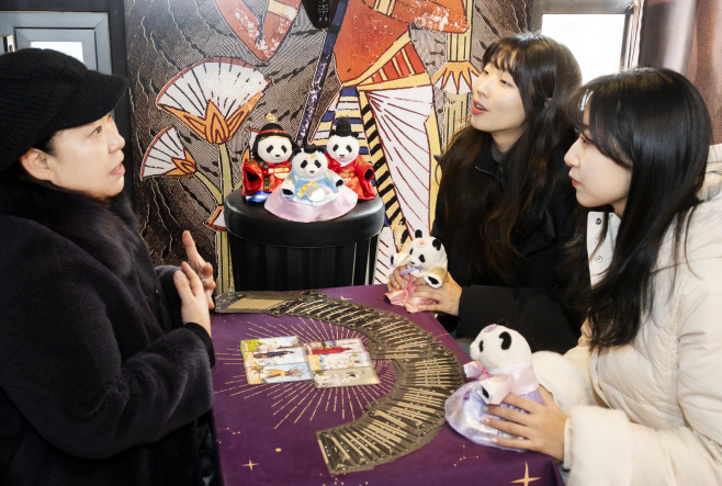 1. 에버랜드 타로점에서 모델들이 신년 바오패밀리 굿즈와 함께 타로를 체험하고 있다