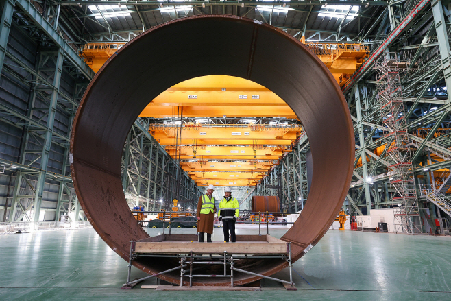 세아윈드에서 시험 생산된 직경 8미터 규모 대형 철강 캔에서 영국 찰스 3세 국왕과 세아제강지주 이주성 사장이 기념사진을 촬영하고 있다.