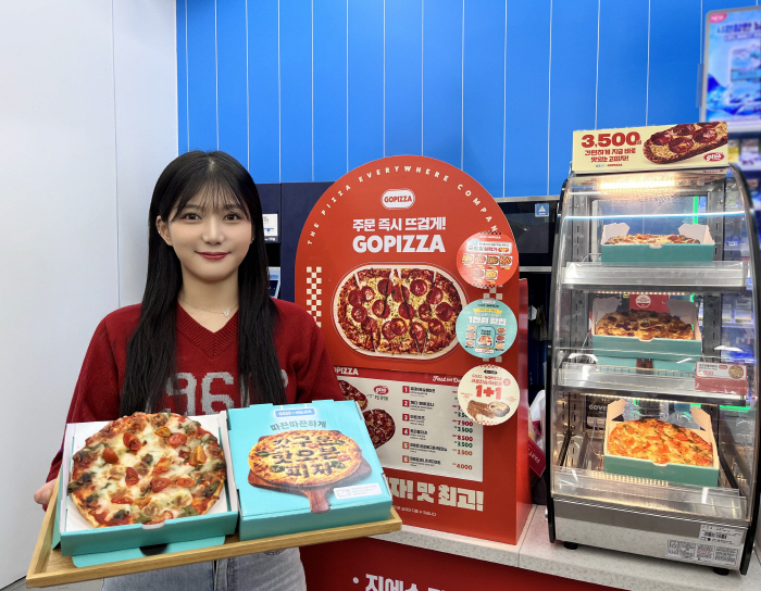 [사진자료1] GS25에서 모델이 배달의민족과 협업해 출시한 피자를 들고 포즈를 취하고 있다
