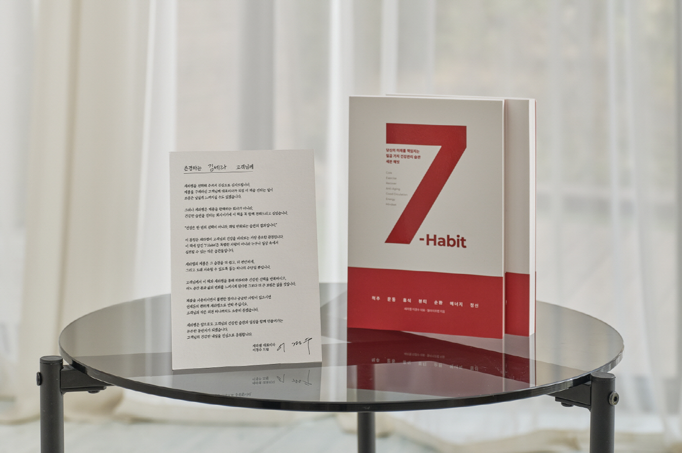 (사진자료1) 세라젬 이경수 대표이사가 고객에게 감사 메시지와 함께 건강한 습관을 전하는 ‘세븐 해빗(7-Habit)’ 도서를 전달한다