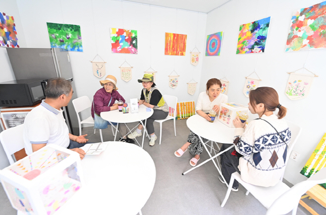 석바대상점가 고객지원센터를 찾은 시민들이 쉼터 공간에 앉아 여유로운 시간을 보내고 있다. 잠시 발걸음을 멈추고 앉은 자리에서 대화를 나누거나 휴식을 취하는 모습이 따뜻하고 편안한 분위기를 자아낸다.