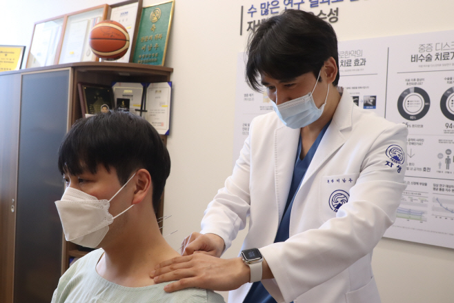 [사진설명] 급성 경항통 환자에게 의료진이 동작침법을 실시하기 위해 자침하고 있다. (출처  자생한방병원)