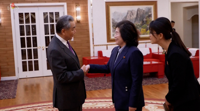 악수하는 최선희 외무상과 왕이 중국 외교부장<YONHAP NO-3484>