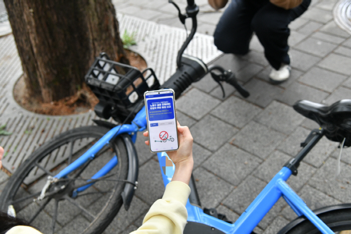 [보도사진3]방치된 공유 전기자전거를 공유모빌리티 통합신고 시스템을 이용해 신고하는 모습