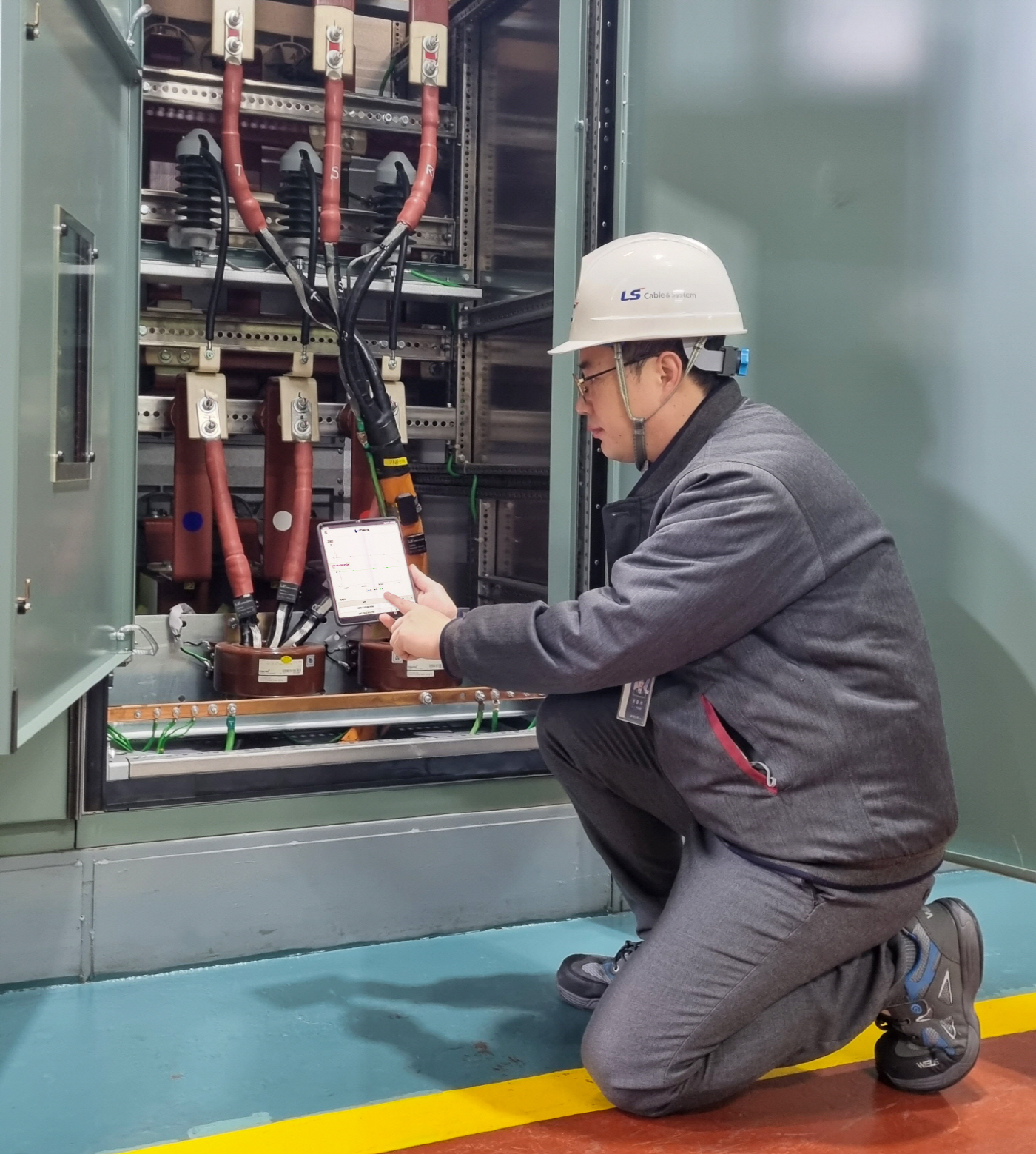 1. LS전선 작업자가 모바일 기기에 설치된 아이체크 시스템 애플리케이션을 통해 배전 케이블의 상태를 실시간으로 모니터링 하고 있다